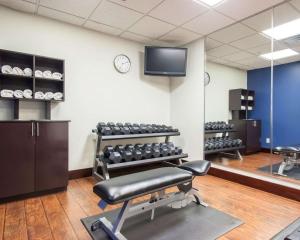 a gym with chairs and a tv on a wall at Comfort Suites Tulsa Central in Tulsa