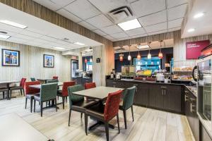 a restaurant with tables and chairs and a counter at Comfort Suites Fairgrounds West in Oklahoma City