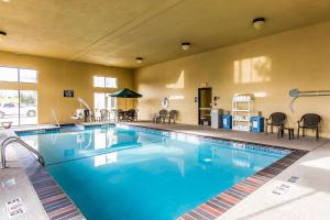 a large pool in a hotel with chairs and tables at Comfort Inn & Suites Ardmore in Ardmore