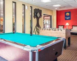 a pool table in a room with a clock on the wall at Comfort Inn & Suites in Elk City