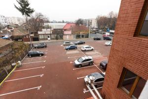 un estacionamiento con autos estacionados en él en Travel Homzzz Apartments en Târgu Mureș