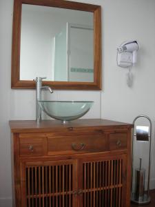 a bathroom sink with a mirror on top of a wooden dresser at Hotel Mona Lisa in La Baule +20 photos
