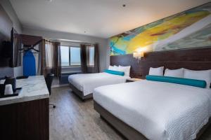 Postel nebo postele na pokoji v ubytování Inn at Rockaway San Francisco Pacifica