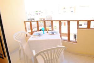 een tafel met 2 stoelen en een wit tafelkleed op een balkon bij Ca' Francisca in Santa Maria