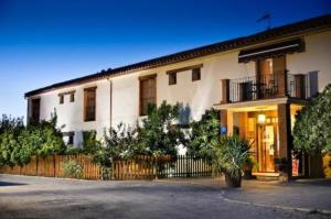 a large white building with a fence in front of it at Hotel La Garapa in Cájar