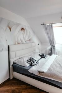 a white bed with a white headboard and a window at Zelný trh 42 in Brno