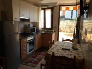 a kitchen with a table and a kitchen with a table and a tableablish at Casa Riveira Grande,Il Apartamentos in Boiro