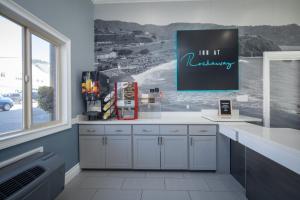 a kitchen with a refrigerator and a painting on the wall at Inn at Rockaway San Francisco Pacifica in Pacifica