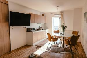 a kitchen and dining room with a table and chairs at Luxury Apartments Zelny Trh 4 in Brno