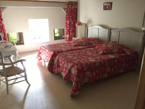 a bedroom with a bed and a table and a window at Auberge de la Cholotte in Les Rouges-Eaux