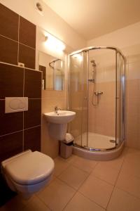y baño con ducha, aseo y lavamanos. en Penzion Ruland, en Brno