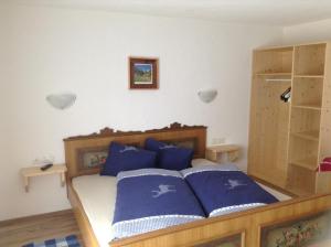 Jausenstation Edelweiß في امهاوسن: غرفة نوم مع سرير ووسائد زرقاء