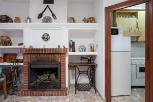 a living room with a fireplace and a kitchen at Casa Cueva Calatrava in Tabernas