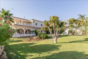 a large house with a tree in the yard at Villa Aurelia Sea views Heatable Pool - Billiard Ping-pong Fooball table - Beach & All at 500 m in La Cala de Mijas