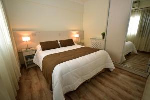 
a bedroom with a bed and a dresser at Gran Hotel Skorpios in Mar del Plata
