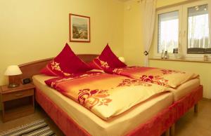 a bedroom with a large bed with red pillows at Haus Neptun in Ostseebad Karlshagen