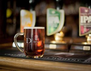 a mug of beer sitting on a bar at Dorset Resort Hotel in East Stoke
