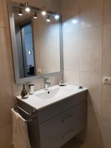 ein Badezimmer mit einem weißen Waschbecken und einem Spiegel in der Unterkunft Luxury Tagara Beach in Puerto de Santiago + 48 Fotos