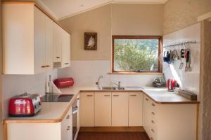 a kitchen with white cabinets and a red appliance at The Cottage at Riverside Farm in Lyndoch