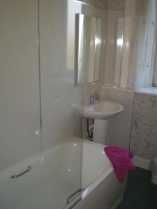 een badkamer met een wastafel, een bad en een wastafel bij No 9 The Guest House Perth in Perth