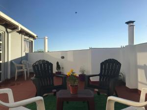 un patio con 2 sillas, una mesa y una valla en Hostal del Milagro en Salta