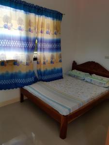 a bed in a room with a curtain at Rosita's Cottages by the Road in Moalboal