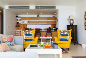 a living room with yellow chairs and a table at The heights ocean views 2 bedrooms in Kata Beach