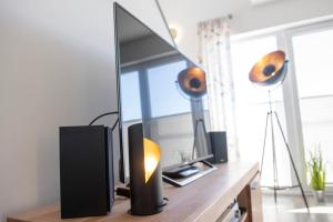 a television on a wooden table with two lamps on it at Hus Twustern in Olpenitz