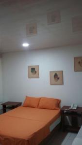 um quarto com uma cama laranja e duas mesas em Edificio Nuevo Conquistador em Cartagena de Indias mais 31 fotografias