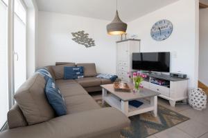 a living room with a couch and a tv at Marina View in Olpenitz