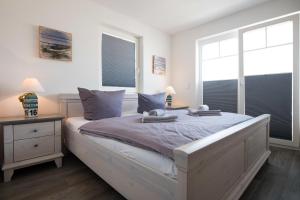 a bedroom with a large bed with two windows at Marina View in Olpenitz