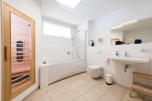 a bathroom with a tub and a sink and a toilet at Hafenlodge in Olpenitz