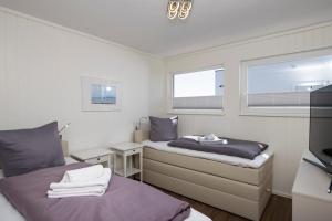 2 camas en una habitación con 2 ventanas en Schwimmendes Haus Triton, en Olpenitz