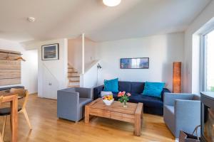 a living room with a blue couch and a table at Am Meer in Olpenitz