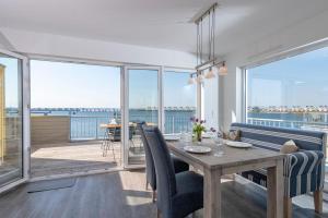a dining room with a table and views of the ocean at Ostwind in Olpenitz