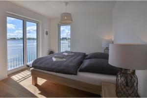 a bedroom with a large bed with a large window at Nantucket in Olpenitz