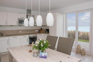 a kitchen with a table with a vase of flowers on it at Schlei Oase in Olpenitz