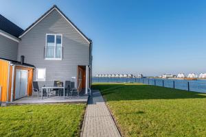 a house with a patio next to the water at Am Meer in Olpenitz
