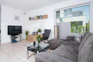 a living room with a couch and a tv at Sternschnuppe in Olpenitz