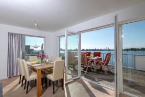 a dining room with a table and views of the water at Durchblick in Olpenitz