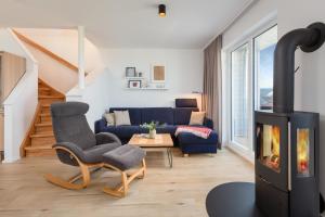 Meerliebe في أوبلينتيز: غرفة معيشة مع أريكة زرقاء ومدفأة