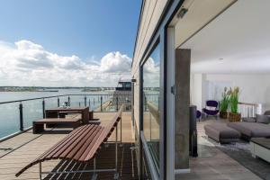 a balcony with a bench and a view of the water at Traumzeit auf der Ostsee in Olpenitz