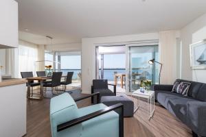 a living room and dining room with a view of the ocean at Hafenheimat in Olpenitz