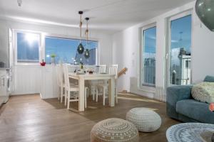 a kitchen and living room with a table and chairs at Schwimmendes Haus Sanibel in Olpenitz