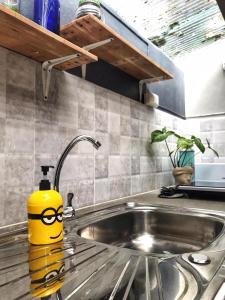 a yellow container with glasses is sitting on a kitchen sink at Bannamhoo Bungalows in Pai