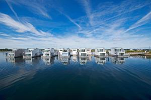 a group of white houses on a body of water at Schwimmendes Haus - Haus im Meer in Olpenitz