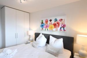 a bedroom with a white bed and a painting on the wall at Long Island in Olpenitz