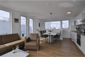 a kitchen and living room with a couch and a table at Schwimmendes Haus Hausboot in Olpenitz