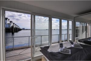 a bedroom with a balcony with a view of the water at Schwimmendes Haus Hausboot in Olpenitz