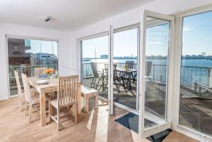 a dining room with a view of the water at Hafenkante in Olpenitz